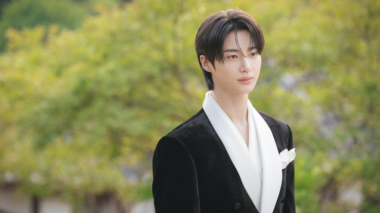 Prince Yi Ahn (Byeon Woo-seok) stands by a line of trees in Perfect Crown