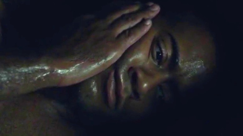 Roland Umber (Ryan Field) clasps his hand to his face in Hannibal
