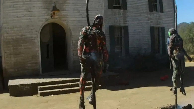 Two charred bodies impaled on stakes sit in front of a church in American Horror Story: Roanoke