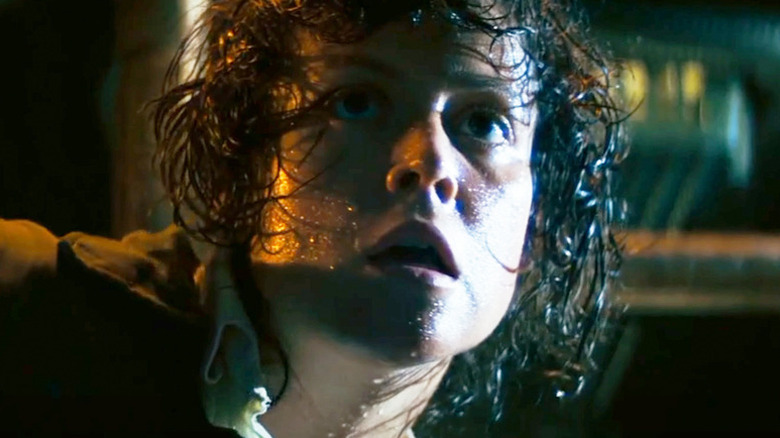 A sweaty Ellen Ripley (Sigourney Weaver) looks up in panic in Alien