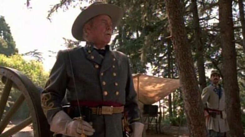 Colonel Q (Harve Presnell) dressed as a Confederate officer stands by a cannon in Star Trek: Voyager