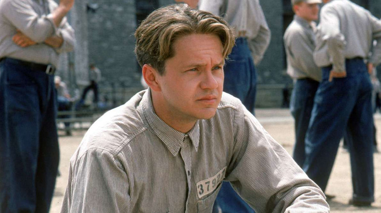 Tim Robbins kneeling in the prison yard as Andy Dufresne in The Shawshank Redemption