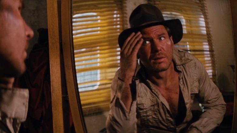 Indiana Jones (Harrison Ford) looking at himself in the mirror in Raiders of the Lost Ark