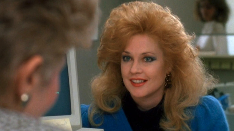 Tess McGill (Melanie Griffith) talking to a colleague near a computer in Working Girl