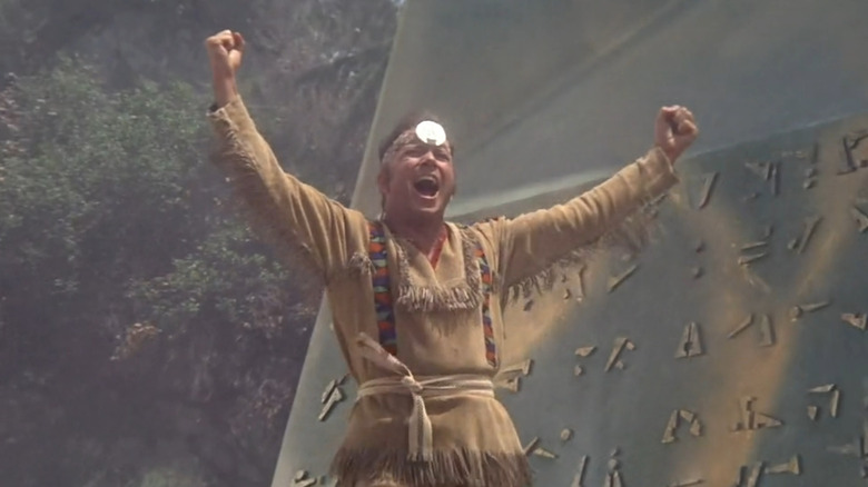 James T. Kirk (William Shatner), wearing Native American clothing, shouts next to an obelisk in Star Trek: The Original Series