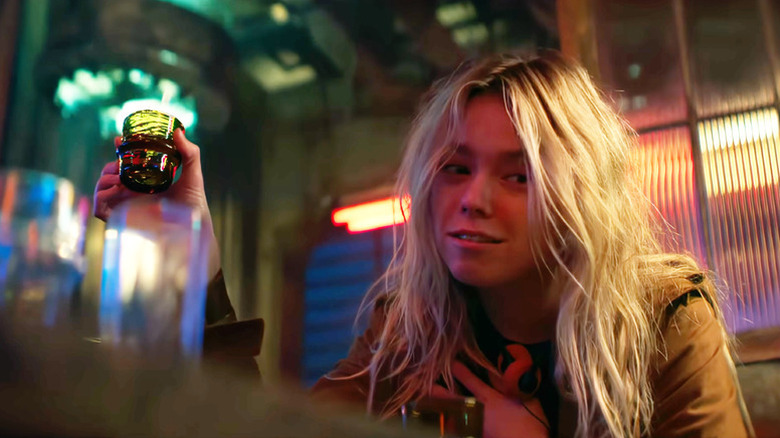 Supergirl (Milly Alcock) holds up a shot glass in Supergirl (2026)