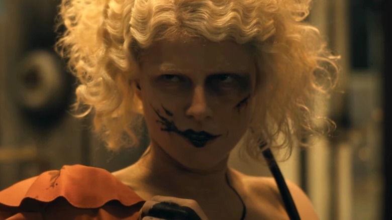 Ida (Jessie Buckley) stares warily with his lipstick smeared in The Bride!