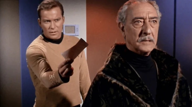 Kirk (William Shatner) offers Kodos (Arnold Moss) a piece of paper in Star Trek: The Original Series