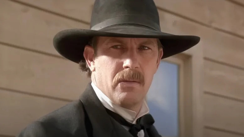 Wyatt Earp (Kevin Costner) stands in a frontier town in Wyatt Earp