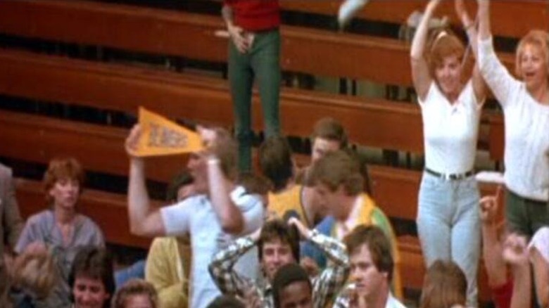 A woman stands up cheering with her pants unzipped in Teen Wolf