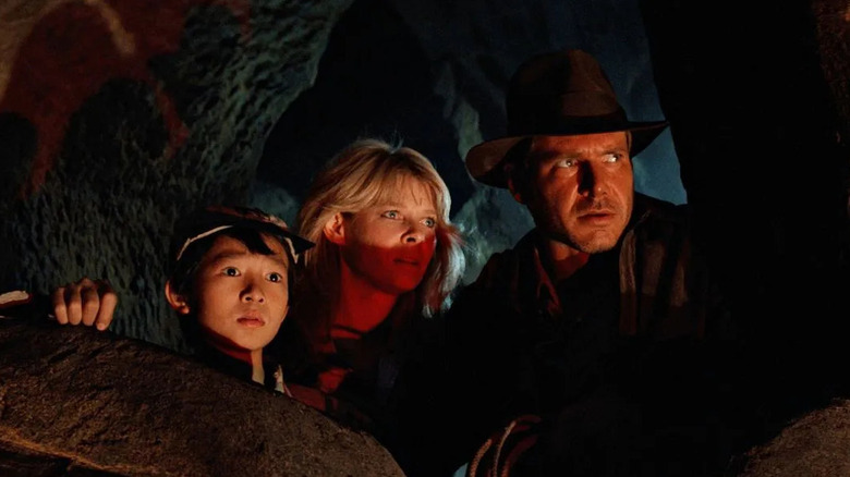 Short Round (Ke Huy Quan), Willie (Kate Capshaw), and Indiana Jones observe a scary ceremony in a cave in Indiana Jones and the Temple of Doom