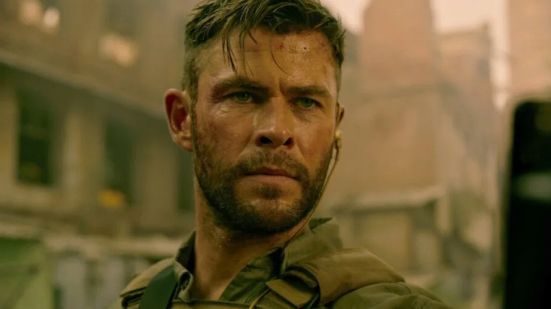 Tyler Rake (Chris Hemsworth) stands in a dusty street in Extraction