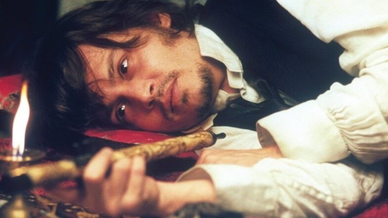 Frederick Abberline (Johnny Depp) lies down studying an opium pipe in From Hell