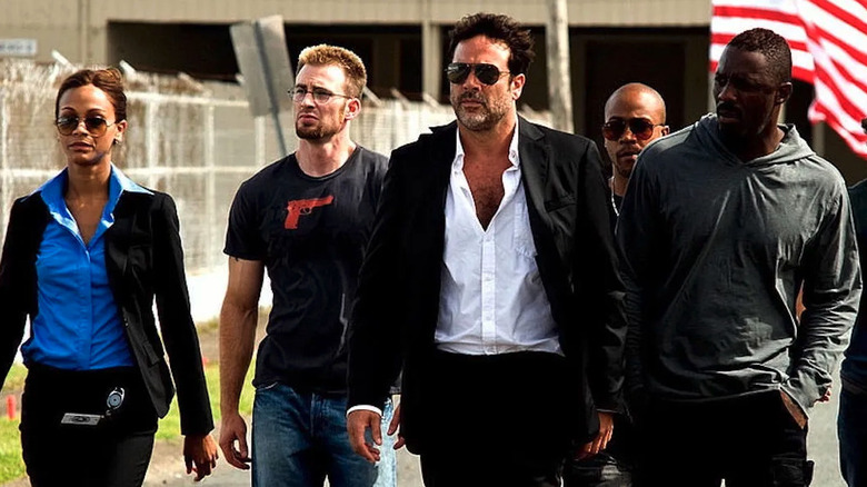 Aisha (Zoe Saldaña), Jensen (Chris Evans), Clay (Jeffrey Dean Morgan), Pooch (Columbus Short), and Roque (Idris Elba) walk across a lot in stands by a lake in a rainforest in The Losers (2010)