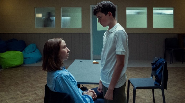 Owen Cooper as Jamie Miller, standing over Erin Doherty as Briony Ariston, in an interrogation room in Adolescence