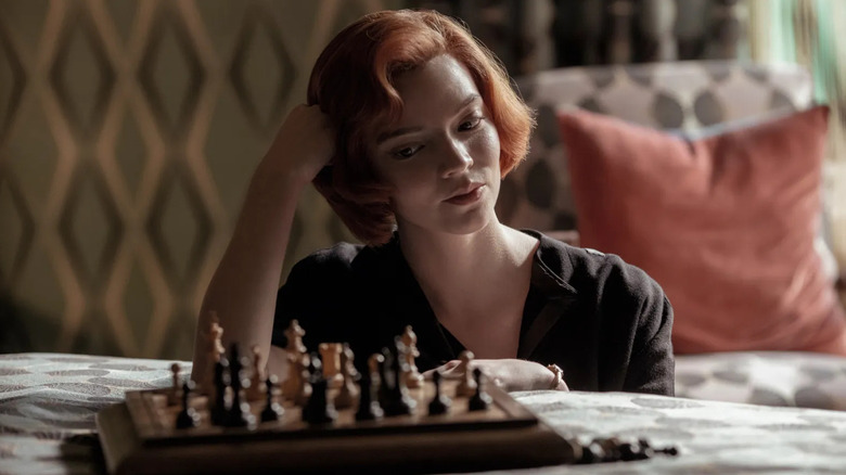 Anya Taylor-Joy as Beth Harmon, looking down at a chess board, in The Queen's Gambit