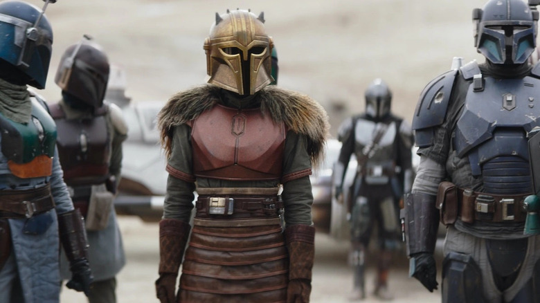 The Armorer flanked by Mandalorians