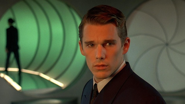 Ethan Hawke as Vincent Freeman in Gattaca, standing in a clinic futuristic space with a green-lit hallway behind him.