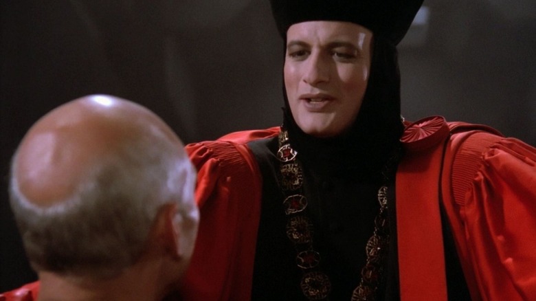 Q (John de Lancie) gloats over Jean-Luc Picard (Patrick Stewart) while wearing judge's clothing in Star Trek: The Next Generation
