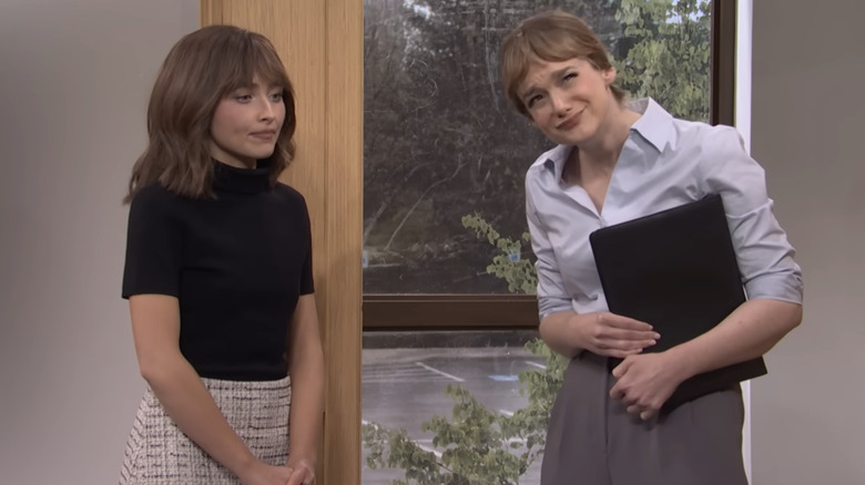 Sabrina Carpenter talking to Ashley Padilla in an office in an SNL sketch