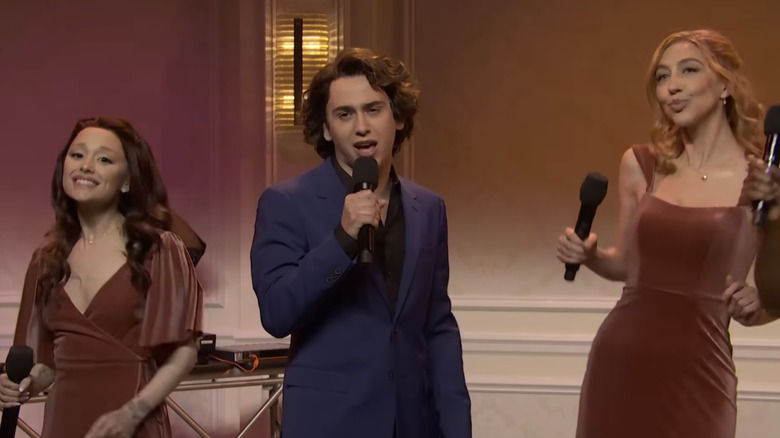 Marcello Hernández as Domingo singing with Ariana Grande and Heidi Gardner as bridesmaids in an SNL sketch