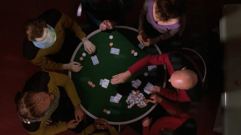An overhead view of Jean-Luc Picard (Patrick Stewart) dealing the senior officers a poker hand in Star Trek: The Next Generation