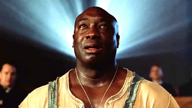 Michael Clarke Duncan as John Coffey, sitting in front of a film projector, in The Green Mile