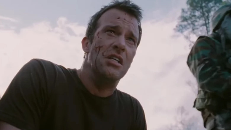 A bloody David Drayton (Thomas Jane) kneels next to a soldier outside in The Mist