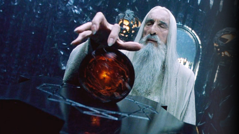 Saruman (Christopher Lee) has a hand hovering over a Palantir in The Lord of the Rings: The Two Towers