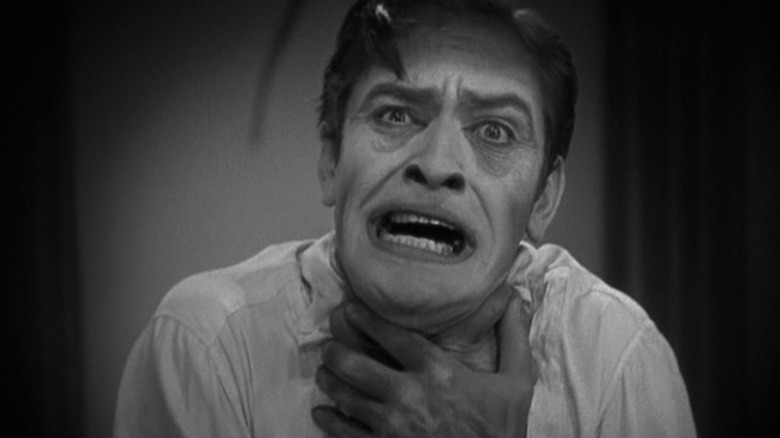 Fredric March as Dr. Jekyll and/or Mr. Hyde, clutching his throat mid-transformation