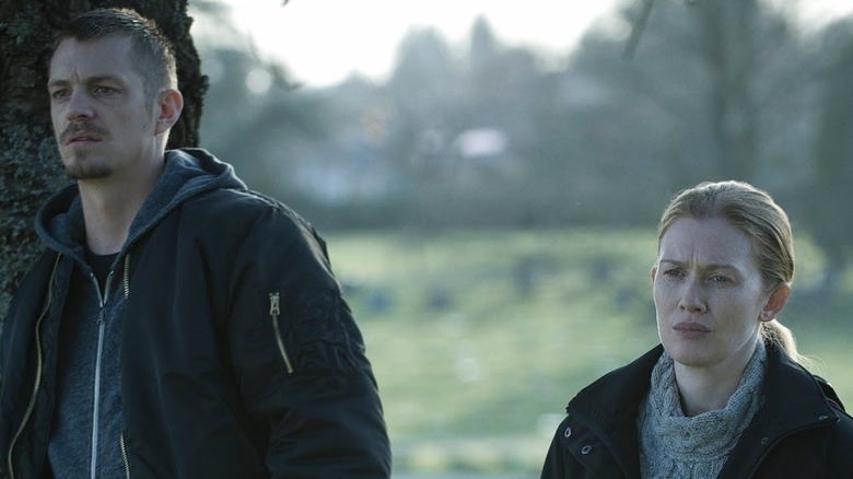 Stephen Holder (Joel Kinnaman) and Sarah Linden (Mireille Enos) examine a funeral in The Killing