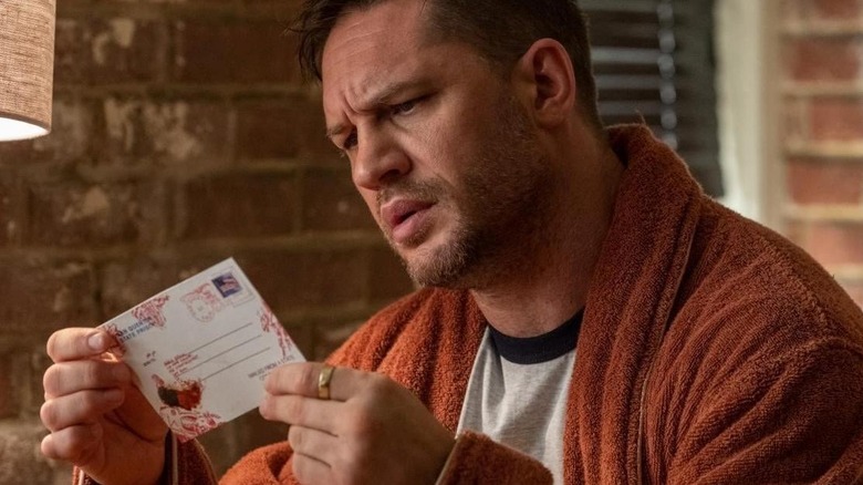 Tom Hardy reads postcard in Venom: Let There Be Carnage