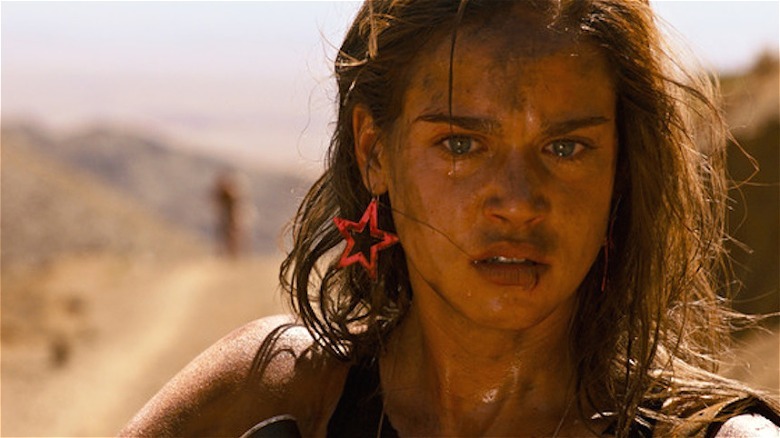 Matilda Lutz standing dirty in desert in Revenge