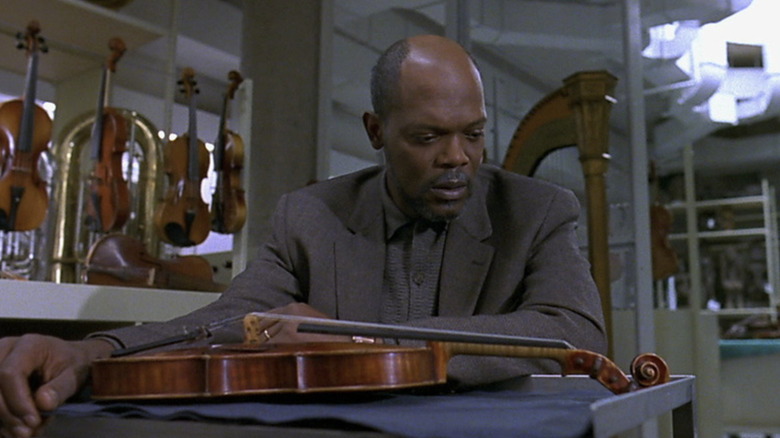 Samuel L. Jackson as Charles Morritz admiring the violin in The Red Violin