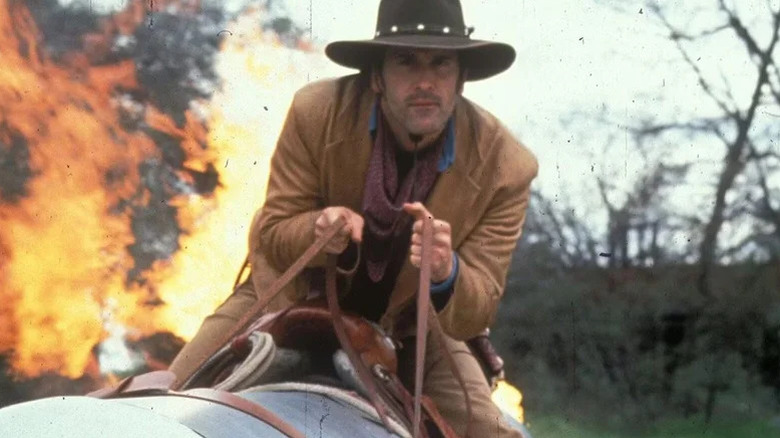 Brisco County Jr. (Bruce Campbell) rides away from a fire on horseback in The Adventures of Brisco County Jr.