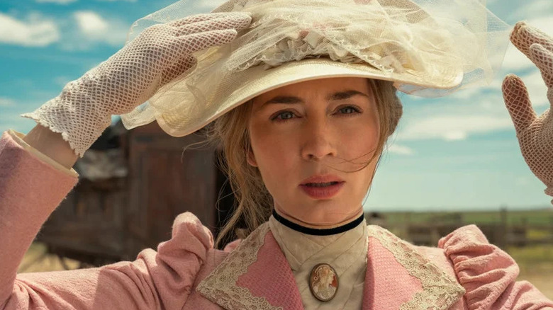 Cornelia Locke (Emily Blunt) adjusts her hat outside in The English