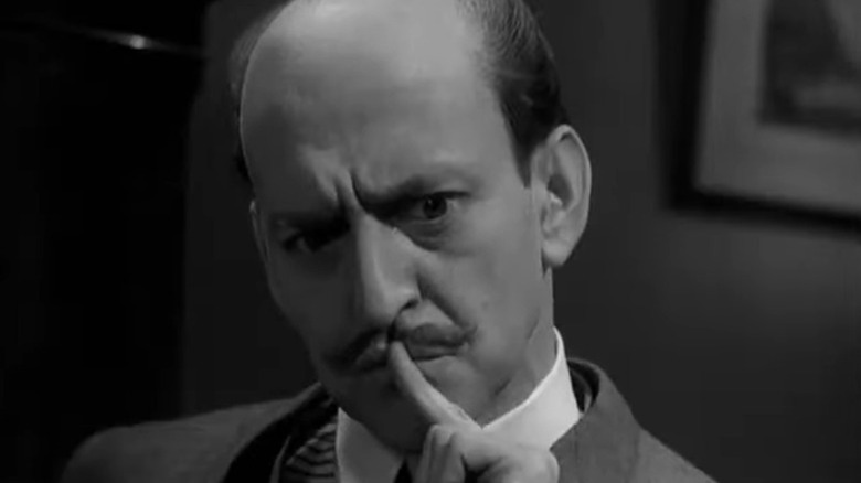 Tony Randall as Hercule Poirot thinking with his finger on his lips in The Alphabet Murders