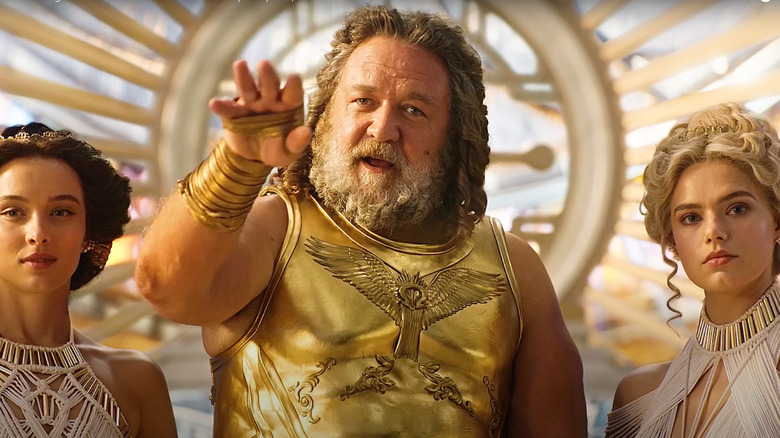 Russell Crowe as Zeus raises his hand in Thor: Love & Thunder