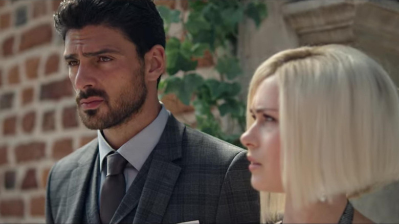 Anna-Maria Sieklucka as Laura Biel and Michele Morrone as Don Massimo Toricelli in 365 Days, standing next to each other, each looking out of frame.