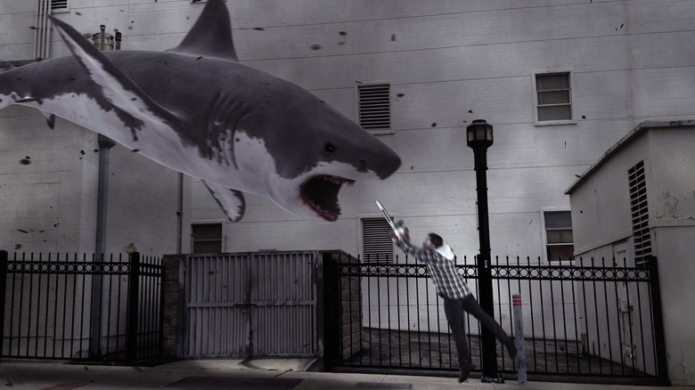 Ian Ziering as Fin "Finley" Shepard in Sharknado, facing a shark flying at him while he defends himself with a chainsaw.