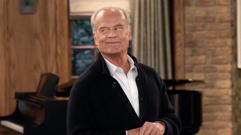 Kelsey Grammer as Frasier Crane, smirking in his home in the 2023 revival of Frasier.