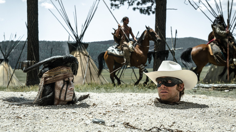 Tonto (Johnny Depp) and John Reid (Armie Hammer) glance at each other while buried up to their necks in The Lone Ranger (2013)