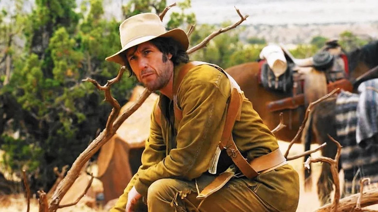 Tommy Dunson Stockburn (Adam Sandler) crouches by a branch in The Ridiculous 6