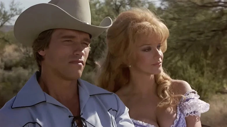 The Handsome Stranger (Arnold Schwarzenegger) and Charming Jones (Ann-Margret) ride together in The Villain (1979)