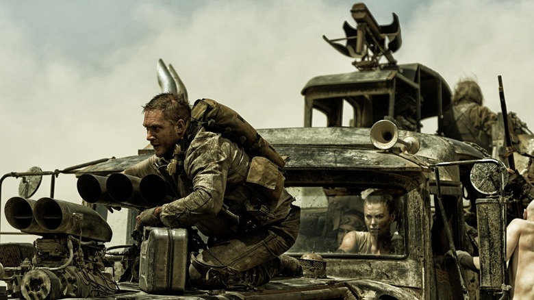 Tom Hardy as Max sitting on the hood of the War Rig in Mad Max: Fury Road