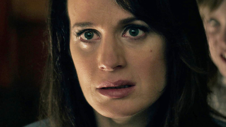Elizabeth Reaser as Alice Zander looking alarmed with a ghoul beside her in Ouija: Origin of Evil