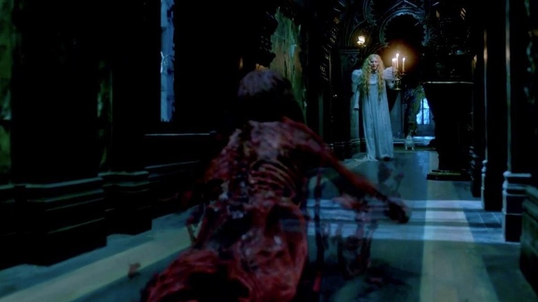 Mia Wasikowska as Edith being pursued down a hallway by a red spirit in Crimson Peak