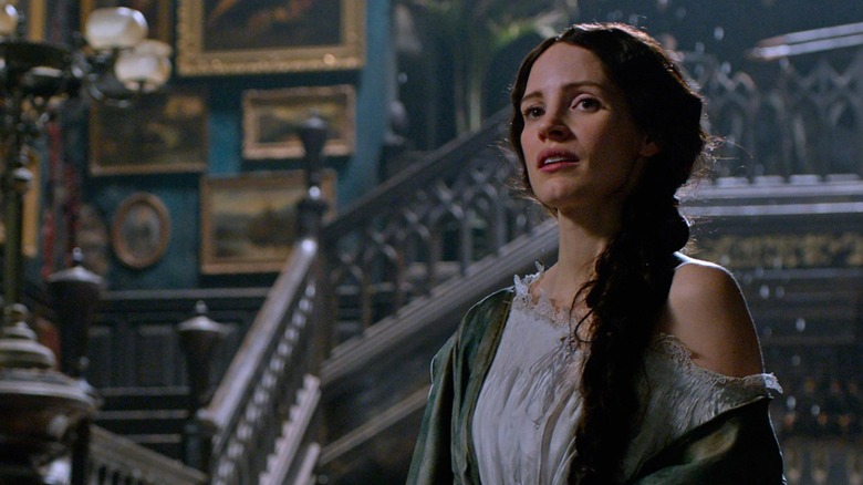 Jessica Chastain as Lucille standing by the staircase in Crimson Peak