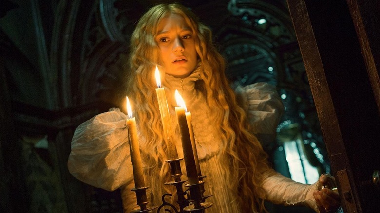 Mia Wasikowska as Edith walking with a candlee stick in Crimson Peak