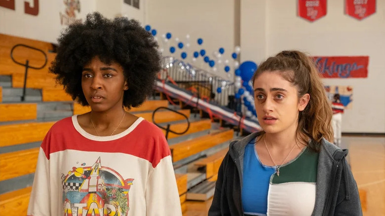 Ayo Edebiri as Josie standing next to Rachel Sennott as PJ in high school gym in Bottoms